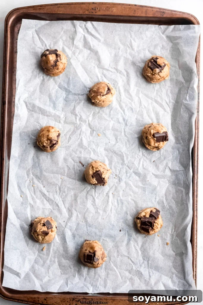 One Bowl Chocolate Chunk Cookies Rows of perfectly portioned chocolate chunk cookie dough balls on a baking sheet, ready for the oven.
