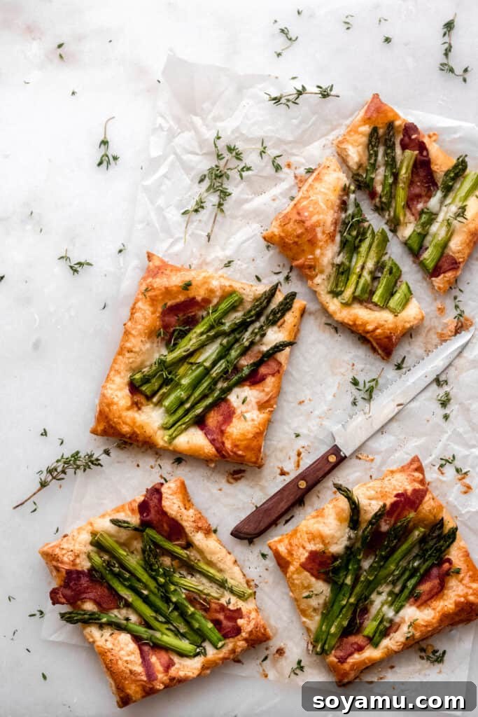 Asparagus Tarts with Bacon and Gruyere - The easiest appetizer or side you'll ever whip up! Made with store-bought puff pastry, fresh asparagus, bacon, and lots of cheese! It's a flavor explosion of sweet, smoky bacon, asparagus, melty cheese, and crisp puff pastry. #asparagus #easterrecipes #asparagus #easyrecipes #easyappetizers #easyeasterrecipes #puffpastry #bacon #gruyere #bluebowlrecipes | bluebowlrecipes.com Golden-brown asparagus tarts with bacon and gruyere, ready to serve.