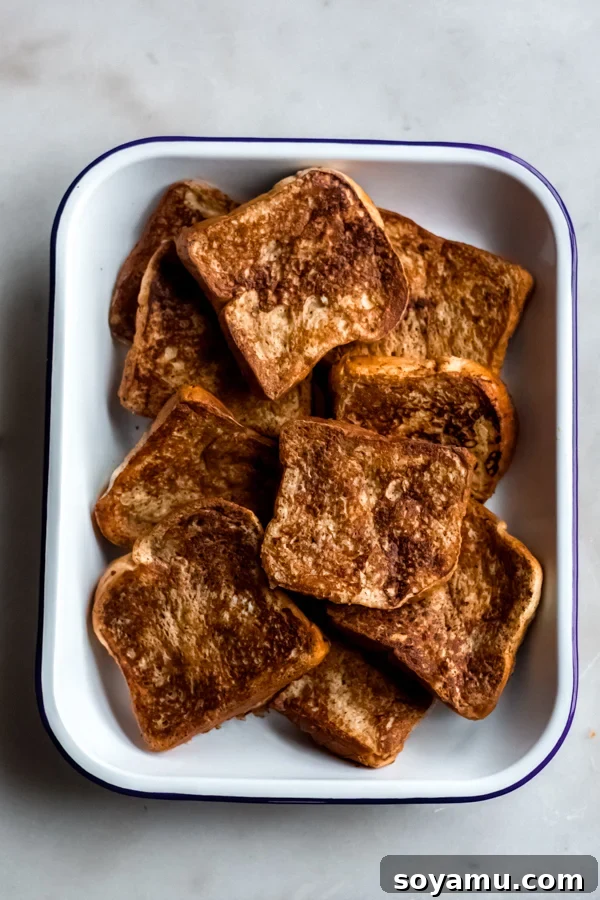 French Toast Sizzling on a Griddle Golden brown French Toast slices sizzling and cooking on a flat electric griddle, showing a perfect crust.