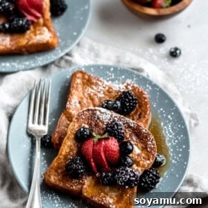 Brioche French Toast Perfection 2 A stacked image of Classic Brioche French Toast with fresh berries and maple syrup.