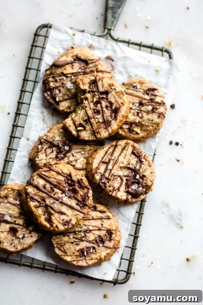 Delicious chocolate pistachio slice and bake cookies arranged on a cooling rack.