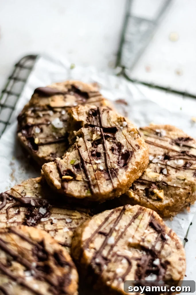 Finished chocolate pistachio cookies with chocolate drizzle and sea salt.
