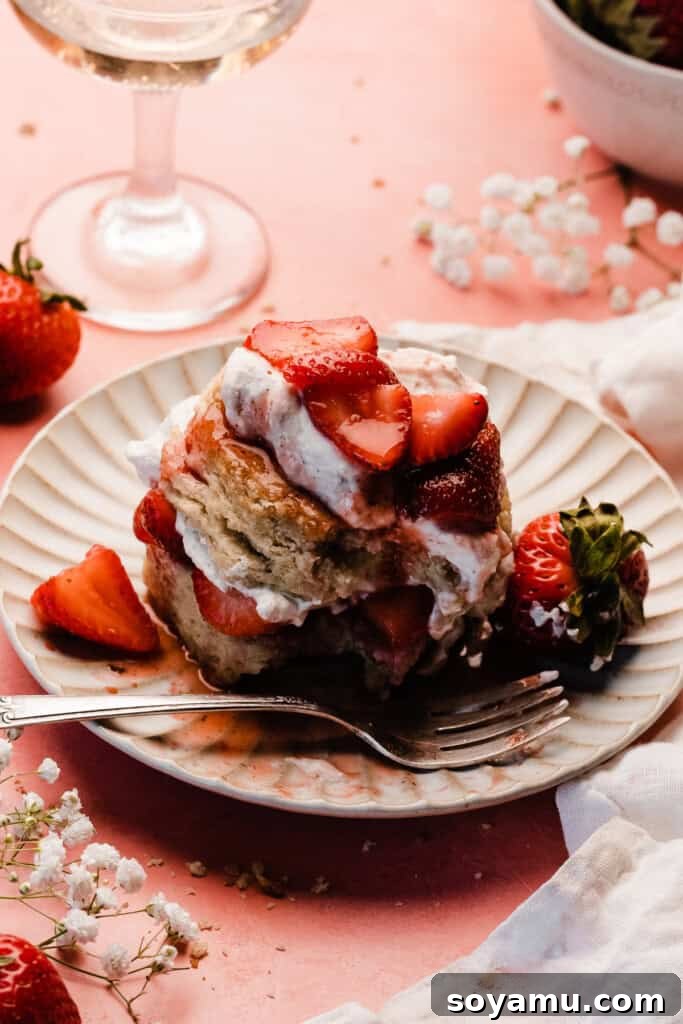 Sun-Kissed Strawberry Shortcakes with Dreamy Whipped Cream 13 A 3/4 view of a strawberry shortcake with a bite missing.