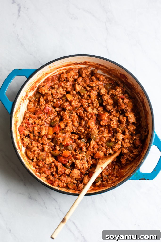 Nourishing Homemade Sloppy Joes 5 Meat, sauce, and peppers cooking and simmering in a pot, creating the sloppy joe filling.