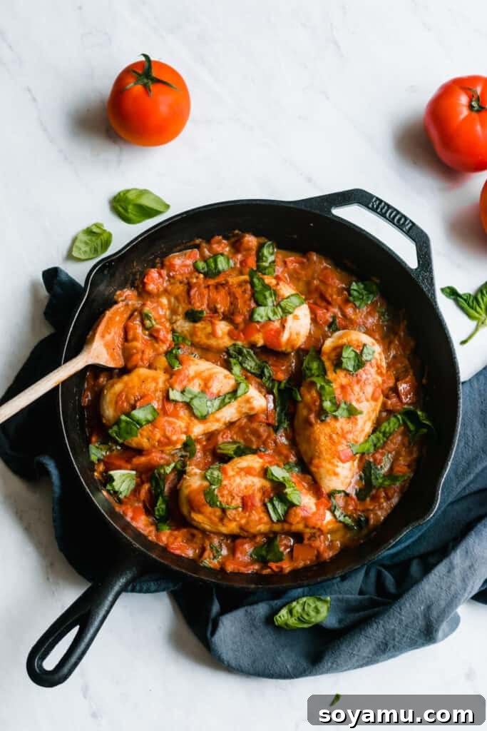Final Dish: Garlic Butter Chicken and Tomato Sauce One pan chicken with garlic butter tomato sauce in a skillet, garnished with basil and ready to eat.