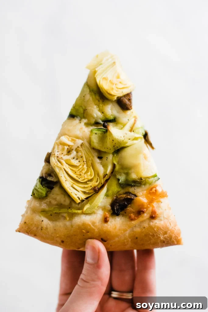 Perfectly Baked Green Goddess Pizza Slice A single slice of vibrant green goddess pizza, showing all the ingredients clearly.