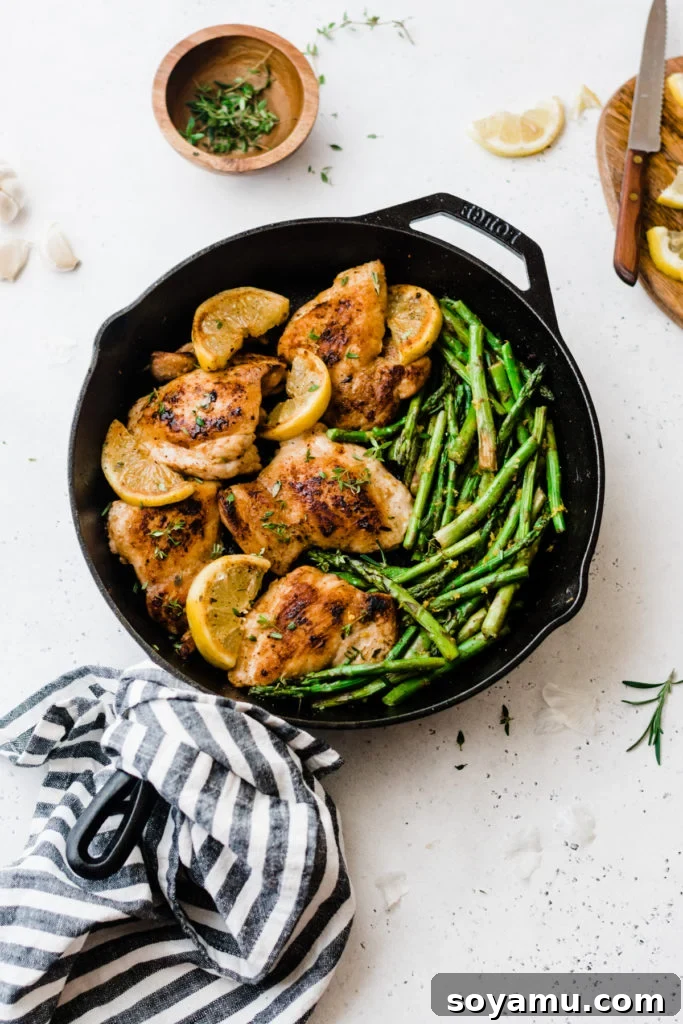 One Pan Lemon Garlic Chicken with Asparagus - A delicious and easy weeknight dinner. Lemon garlic chicken and asparagus in a cast iron skillet, ready to serve.