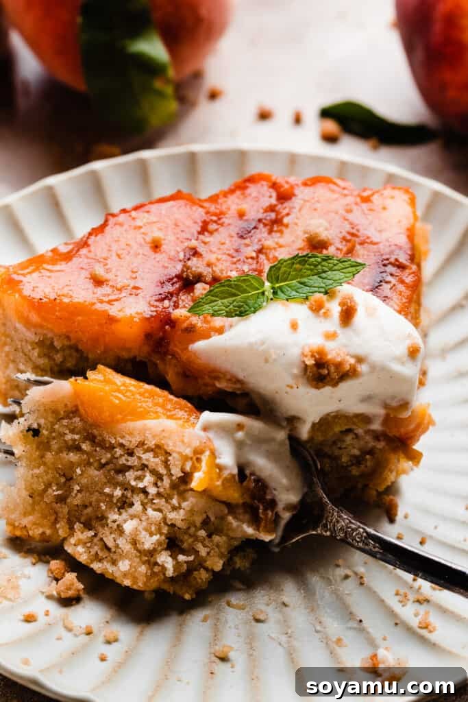 Caramelized Peach Cobbler Flip 3 A close-up on a fork taking a bite out of peach upside down cake.