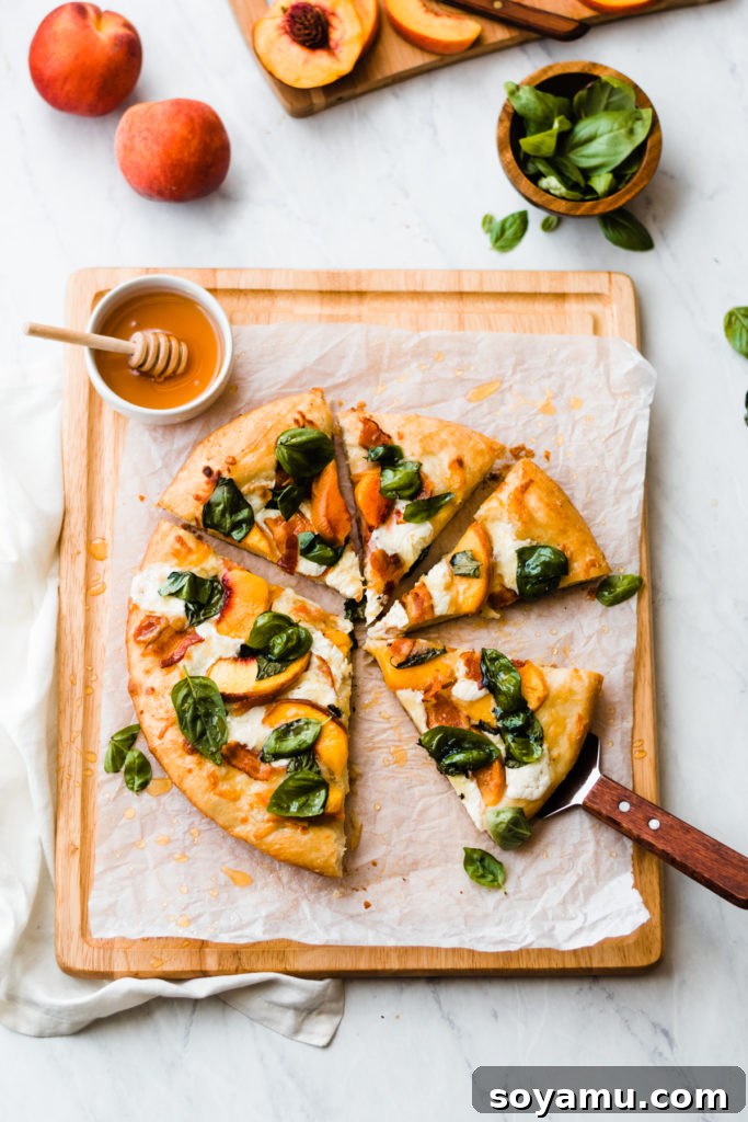 Sliced peach pizza with bacon and basil on a wooden cutting board, ready to serve.