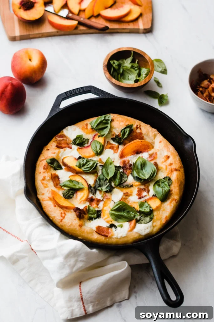 Freshly baked peach pizza cooling in a cast iron skillet.