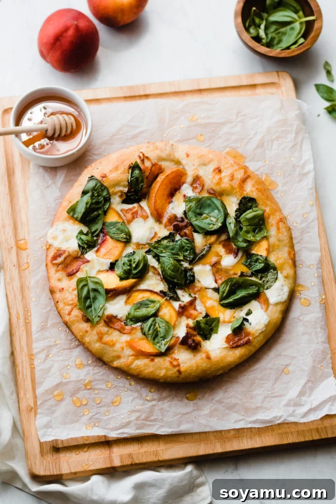 Another perspective of the peach pizza on a wooden cutting board, showcasing its rustic charm.