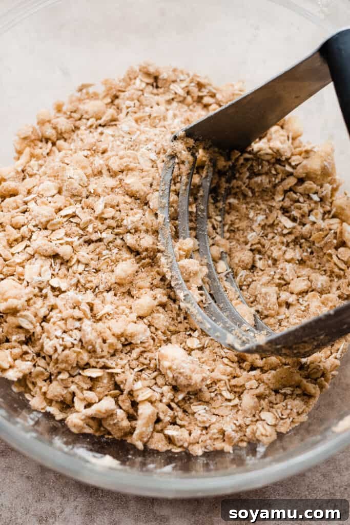 Heavenly Brown Butter Peach Crisp 6 A close-up of the crumbly crisp topping mixture in a bowl, showing oats, flour, brown sugar, and pieces of butter.