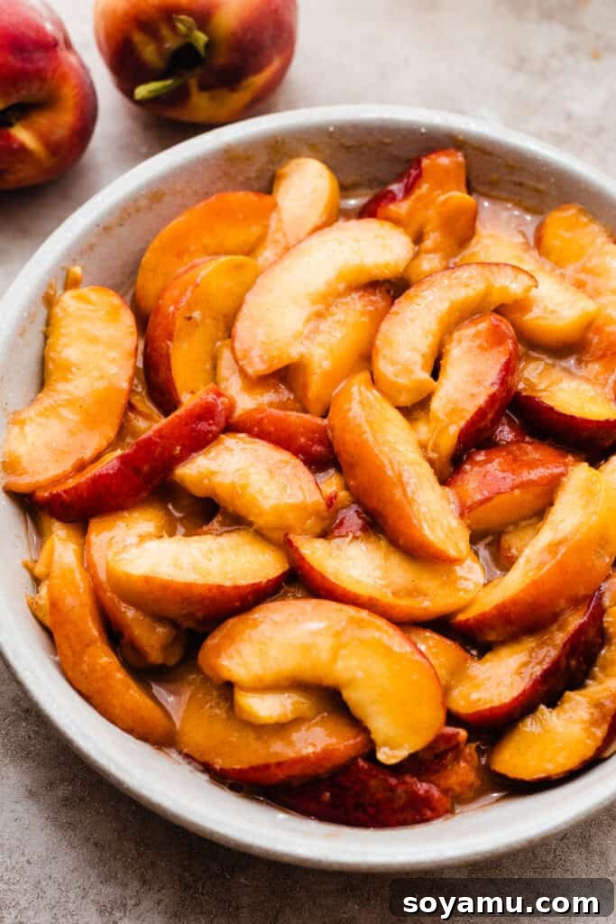 Heavenly Brown Butter Peach Crisp 7 The juicy peach filling in a baking dish, glistening with released juices, ready for the topping.