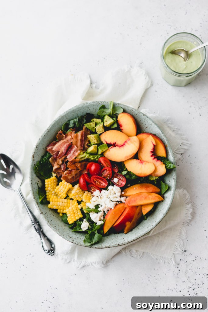 A bowl of peach nectarine salad, featuring a generous portion of fruit, vegetables, and bacon.