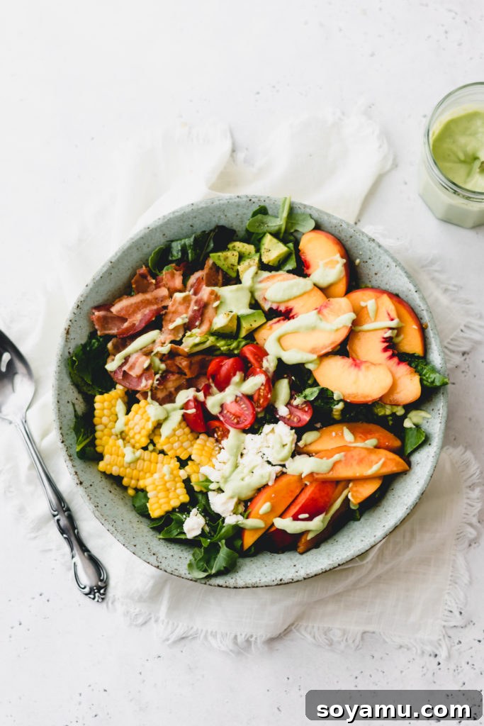 Close-up of peach nectarine salad with creamy avocado dressing drizzled over it.