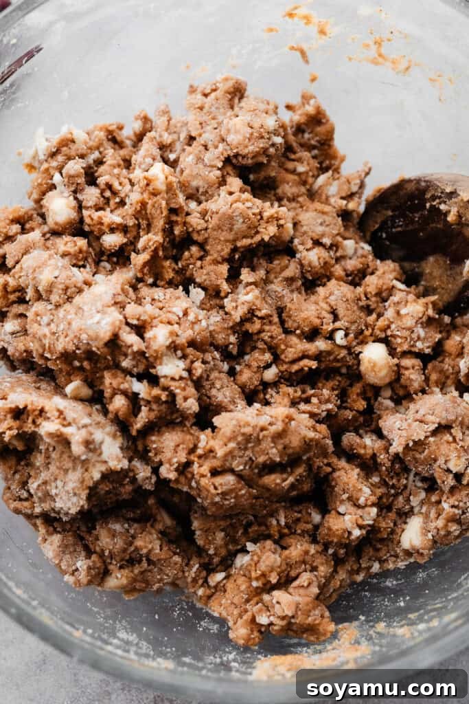 A bowl of the scone dough after wet and dry ingredients are combined. Keywords: Scone Dough Mixing, Wet Ingredients, Dough Formation.