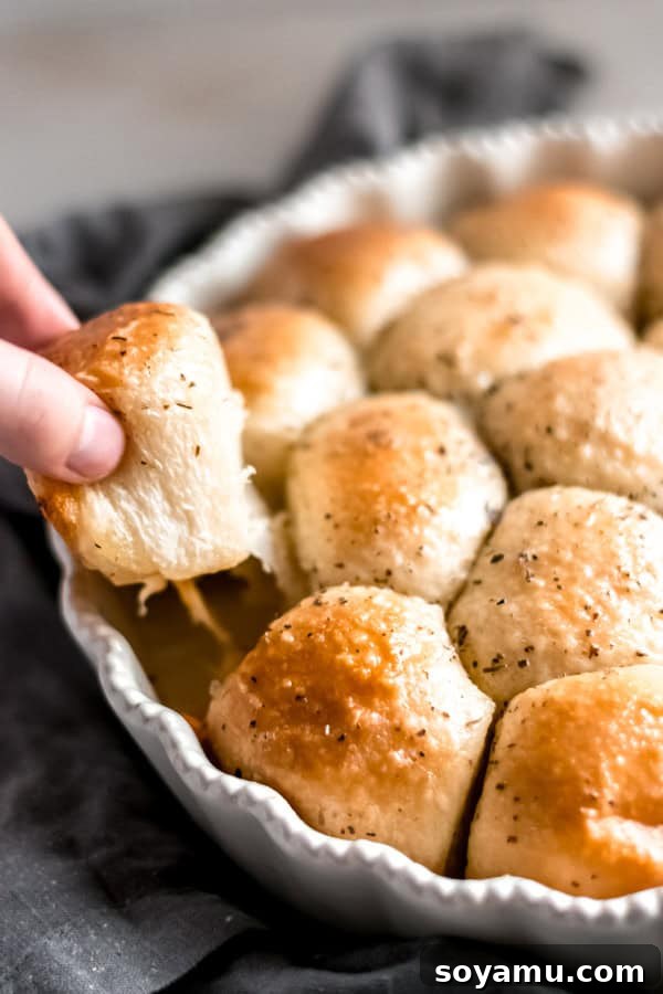 Cheesy Garlic Herb Pull Apart Rolls Golden cheesy garlic herb pull apart rolls, torn open to reveal melted cheese, fresh from the oven and ready to be enjoyed.