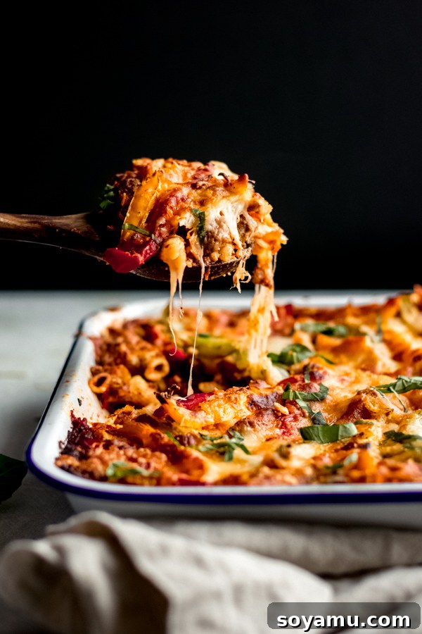 Cheesy Pasta Bake with Sausage and Peppers A bubbling cheesy pasta bake with sausage and colorful bell peppers, fresh from the oven and ready to be served as a comforting main dish.