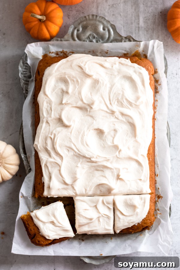 Pumpkin Spice Sheet Cake with Cream Cheese Frosting A festive pumpkin spice sheet cake generously topped with luscious cream cheese frosting, decorated for a fall celebration.