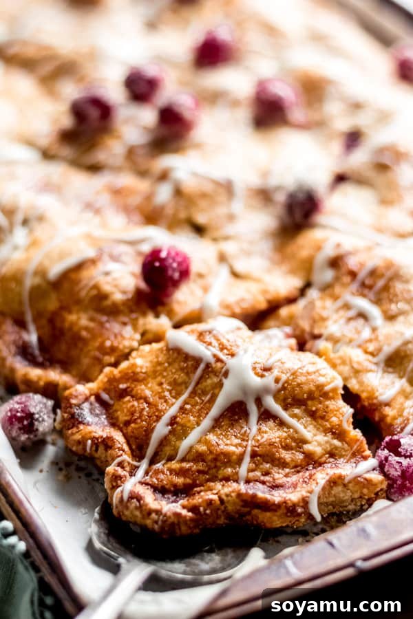 Cranberry Apple Slab Pie with Maple Glaze A large rectangular cranberry apple slab pie with a beautiful maple glaze, cut into squares for serving a crowd.