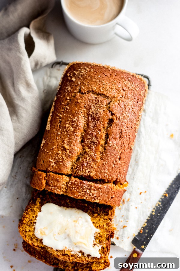The Best Pumpkin Bread A perfectly baked loaf of moist pumpkin bread with a crunchy raw sugar topping, sliced and ready to be enjoyed.