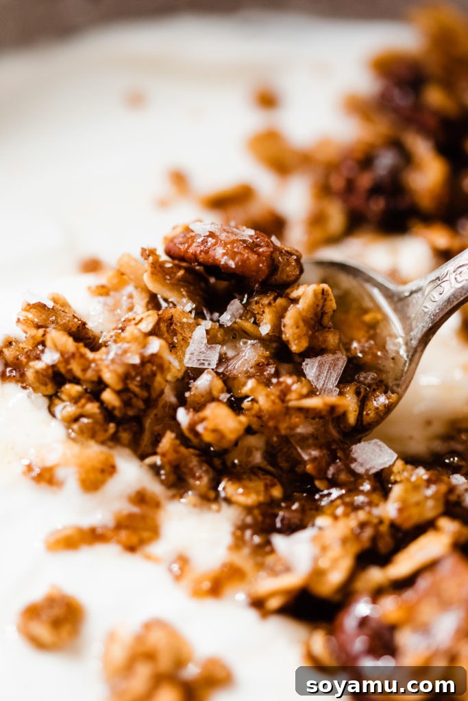 A bowl of homemade pumpkin granola, golden brown and speckled with oats and pecans.