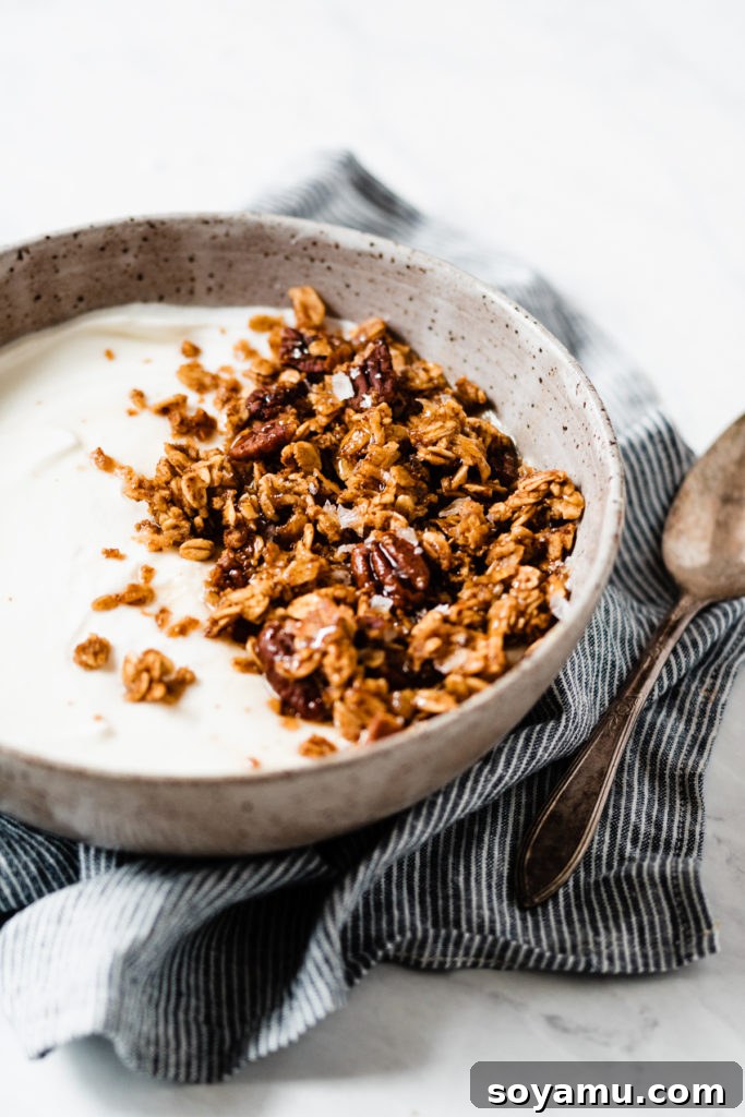 A beautifully styled shot of pumpkin granola in a bowl with autumnal decorations.