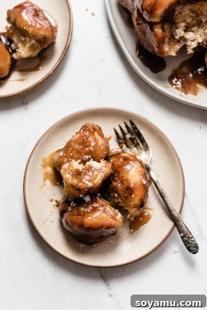 Golden-brown Caramel Apple Cider Monkey Bread on a serving plate, ready to be pulled apart and enjoyed by a group.