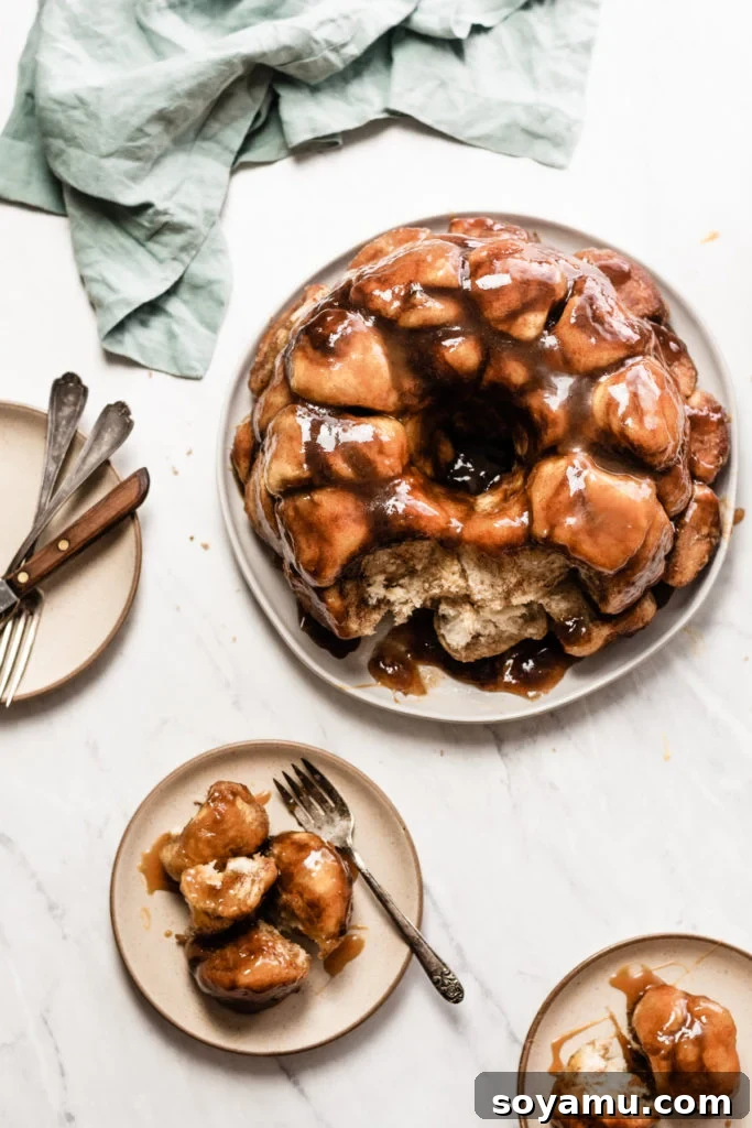 A close-up of the Caramel Apple Cider Monkey Bread, showcasing its fluffy texture, golden crust, and generous coating of sweet caramel sauce.