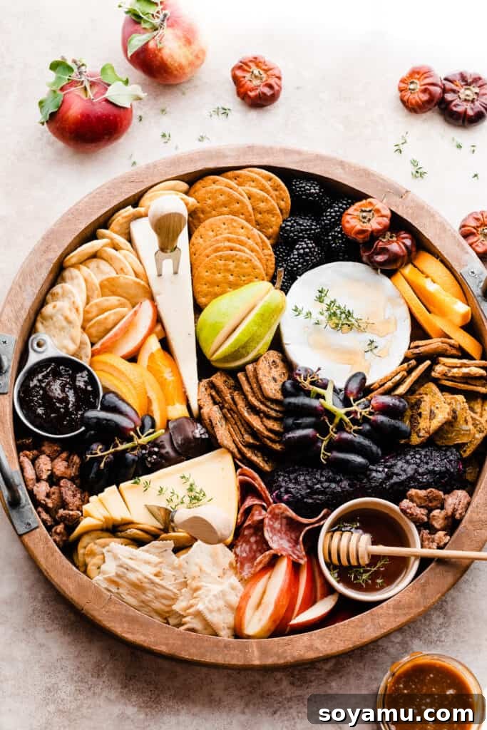 Autumn Bounty Board 5 A captivating bird's eye view of the entire fall cheese board, featuring honey, fresh figs, an array of crackers, a log of goat cheese, and various other autumnal delights.
