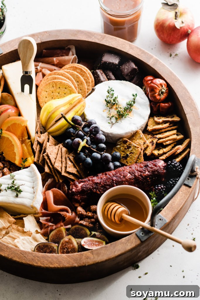 Fall Harvest Cheese Board - A beautiful autumn spread for entertaining. A beautifully presented fall cheese board resting on a light surface, complemented by decorative mini pumpkins and fresh apples in the background, creating a festive autumn scene.