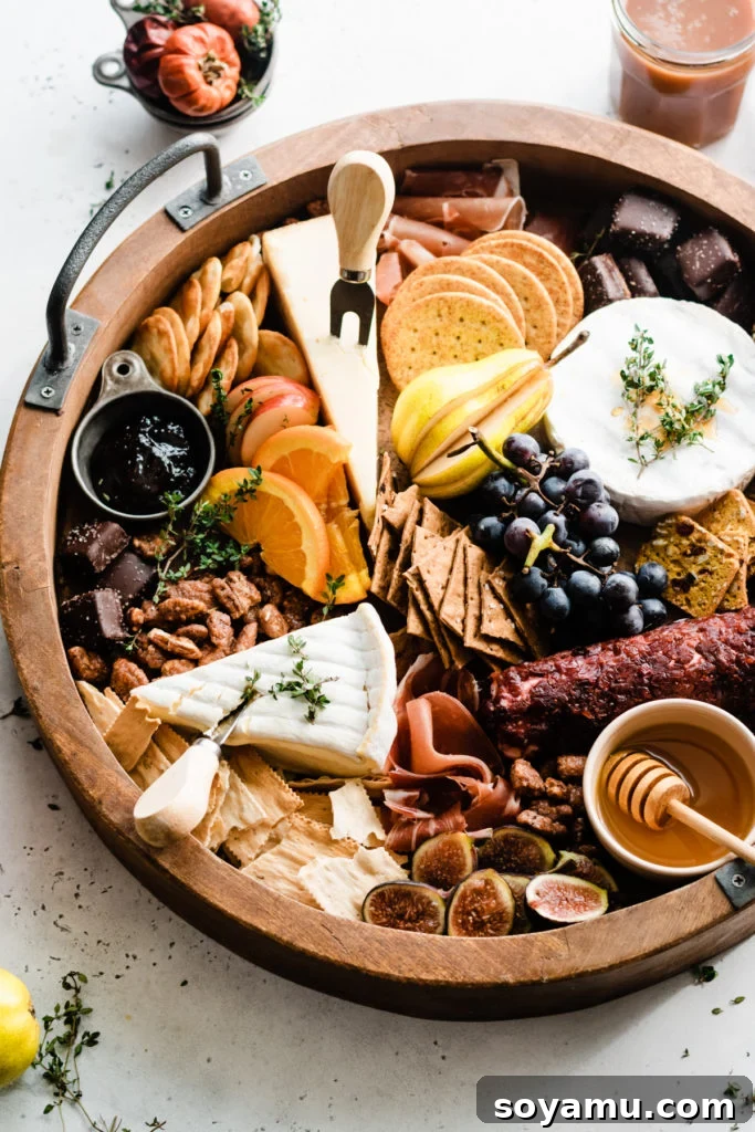 Fall Harvest Cheese Board - Your perfect autumn entertaining centerpiece. A stunning round wooden cheese board, generously filled with the vibrant bounty of autumn, featuring a mix of cheeses, fruits, crackers, and festive garnishes.