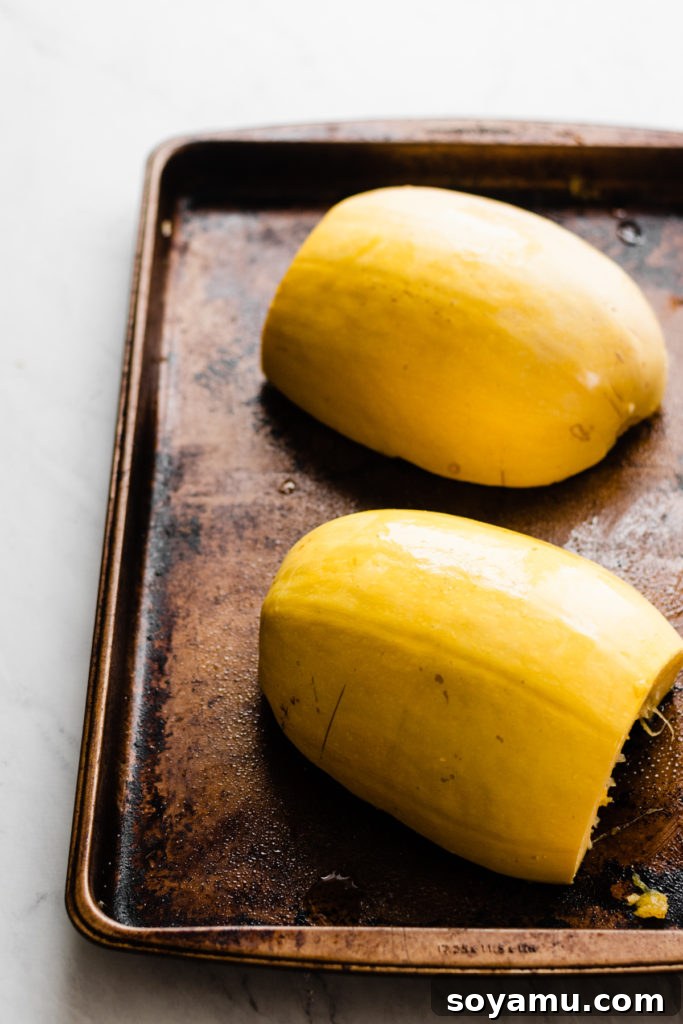 Roasting Spaghetti Squash: Cut Side Down for Best Results Spaghetti squash halves roasting cut-side down on a baking sheet.