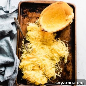 Unlock the Secret to Perfect Spaghetti Squash 2 A top-down shot of a beautifully roasted spaghetti squash half on a baking sheet.
