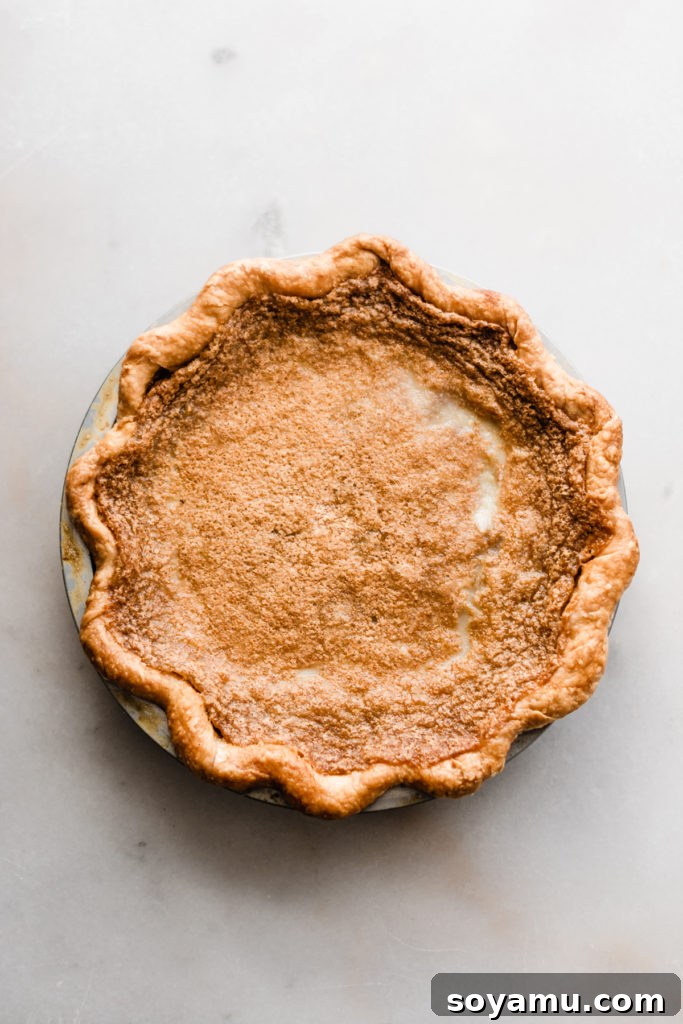 Maple custard pie, cooling and ready for its finishing touches Maple Pie cooling after baking, revealing its perfectly set custard filling and golden crust
