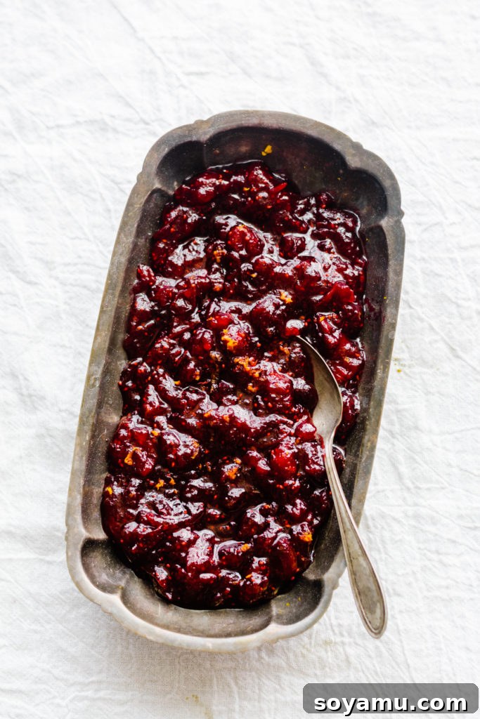 Artisanal Maple Cranberry Sauce 8 An elegantly styled serving dish of homemade cranberry sauce, perfectly set on a crisp white tablecloth, showcasing its rich texture and festive charm, ready for a holiday meal.