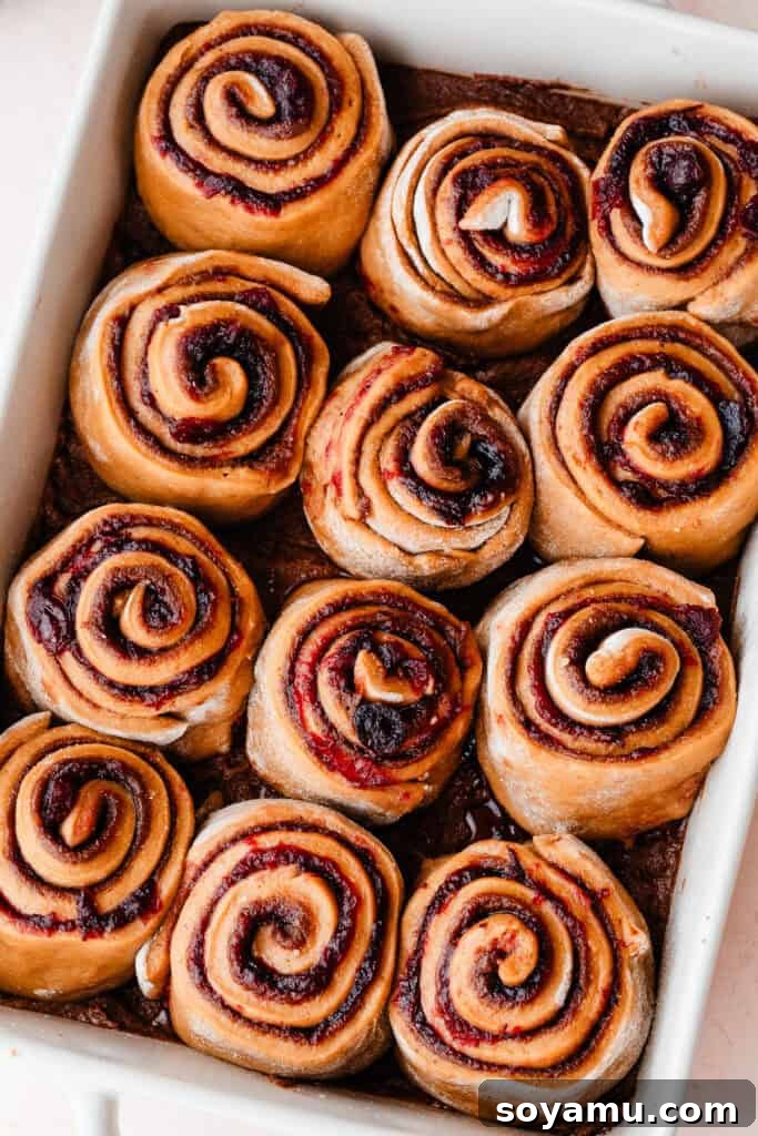 The perfectly risen gingerbread cinnamon rolls arranged snugly in a baking pan, ready for baking.