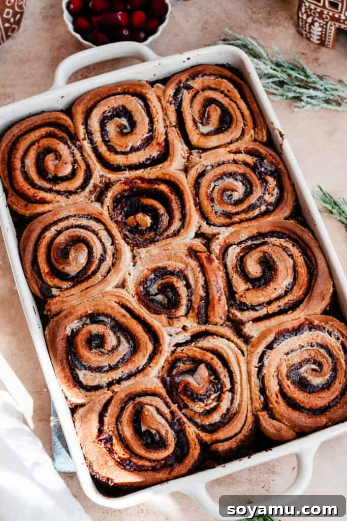 The golden-brown baked gingerbread cinnamon rolls in their pan, looking tender and ready for frosting.