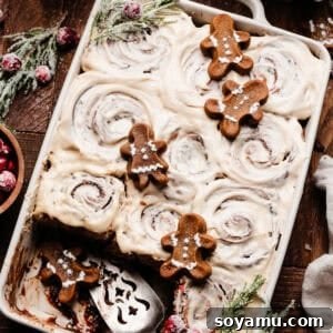 A pan of gingerbread cinnamon rolls on a wooden surface.