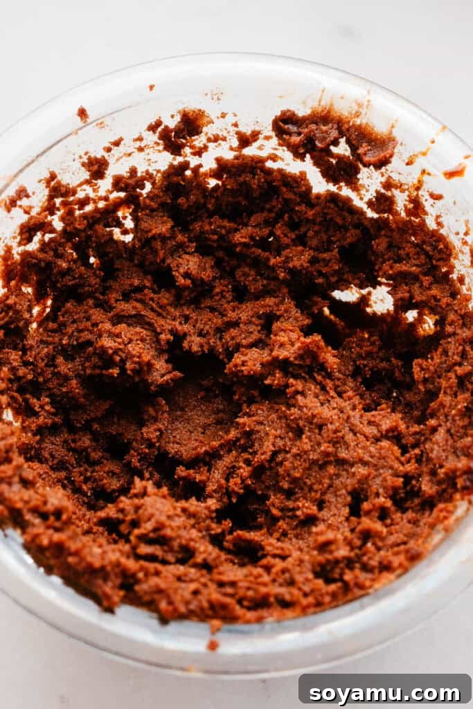 A bowl filled with the creamy, spiced gingerbread cinnamon filling, ready to be spread onto the dough.