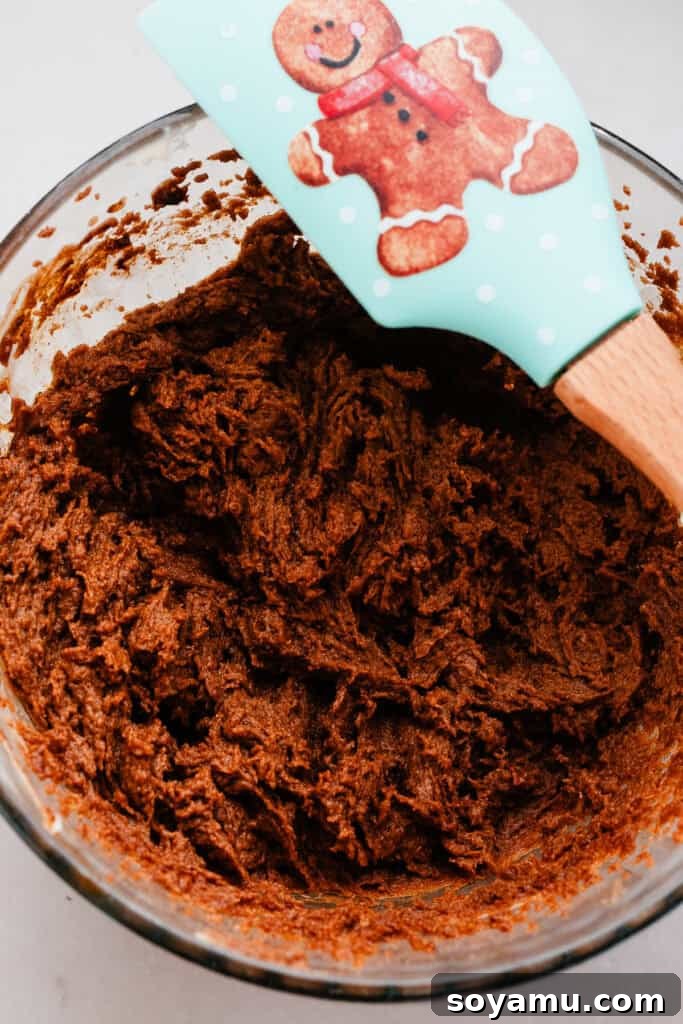A bowl containing the rich, dark gingerbread caramel pan sauce, smooth and ready to line the baking pan.