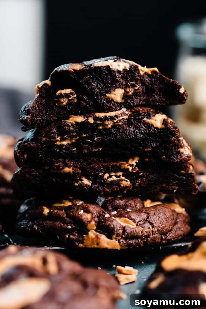 Double Chocolate Caramelized White Chocolate Cookies 3 A beautifully stacked display of warm chocolate cookie halves, revealing their gooey, rich interiors and melting caramelized white chocolate chunks.
