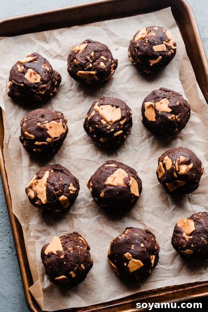Double Chocolate Caramelized White Chocolate Cookies 7 Perfectly scooped, uniform balls of chocolate white chocolate chip cookie dough arranged on a baking sheet, ready for chilling.