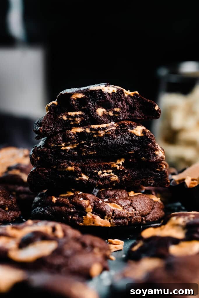 Double Chocolate Caramelized White Chocolate Cookies 9 A stack of perfectly baked chocolate white chocolate chip cookie halves, showcasing their gloriously gooey, fudgy centers and generous chunks of caramelized white chocolate.