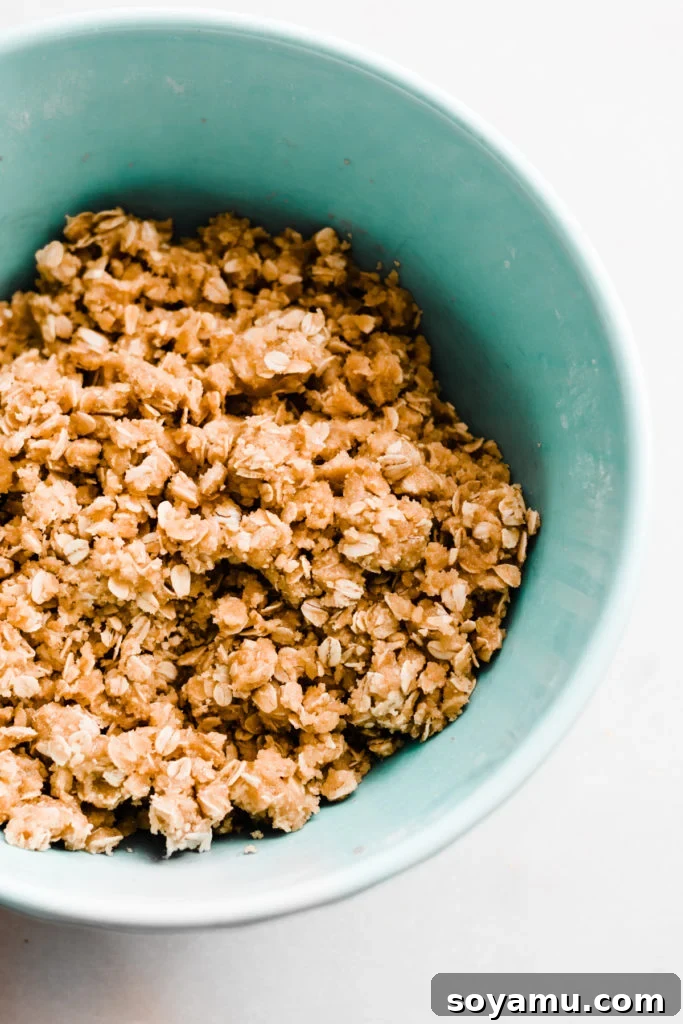 An overhead view of a pan of Cranberry White Chocolate Crumble Bars, with several pieces already cut and arranged for serving, highlighting their inviting texture.