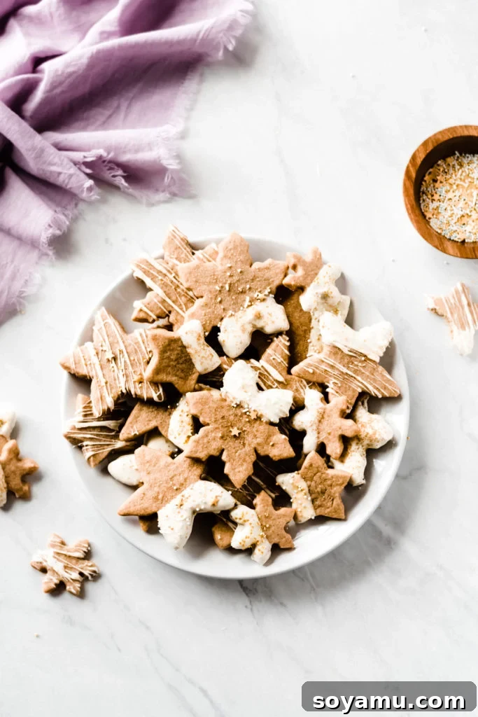 Beautifully Decorated Cinnamon Maple Cutout Cookies Several Cinnamon Spiced Maple Cutout Cookies, some dipped in white chocolate and decorated, arranged artfully for a festive presentation.