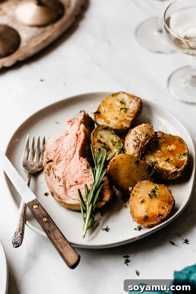 A final presentation of the magnificent lamb roast and potatoes. Lamb Roast with Herbed Garlic Butter Potatoes ready to serve - A final overhead shot of the beautifully roasted lamb leg surrounded by golden herbed garlic butter potatoes, garnished with fresh herbs, ready to be enjoyed as a festive meal. #GourmetDinner #Foodie #RecipeInspiration #EasyEntertaining #DeliciousFood