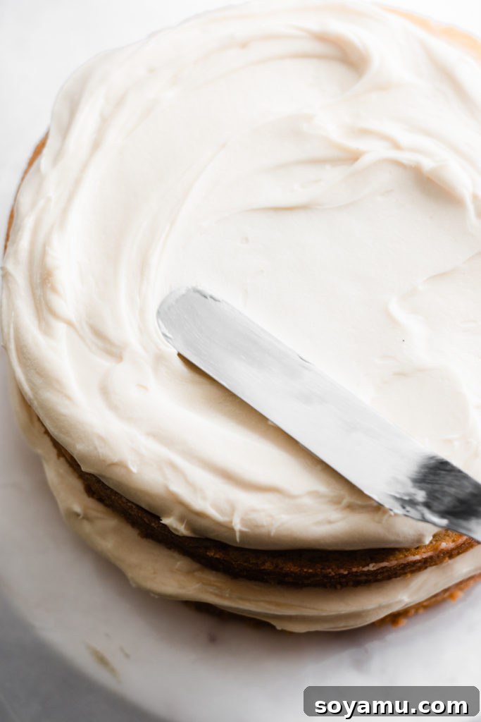 Spreading frosting between cake layers Layering cake with caramelized white chocolate frosting