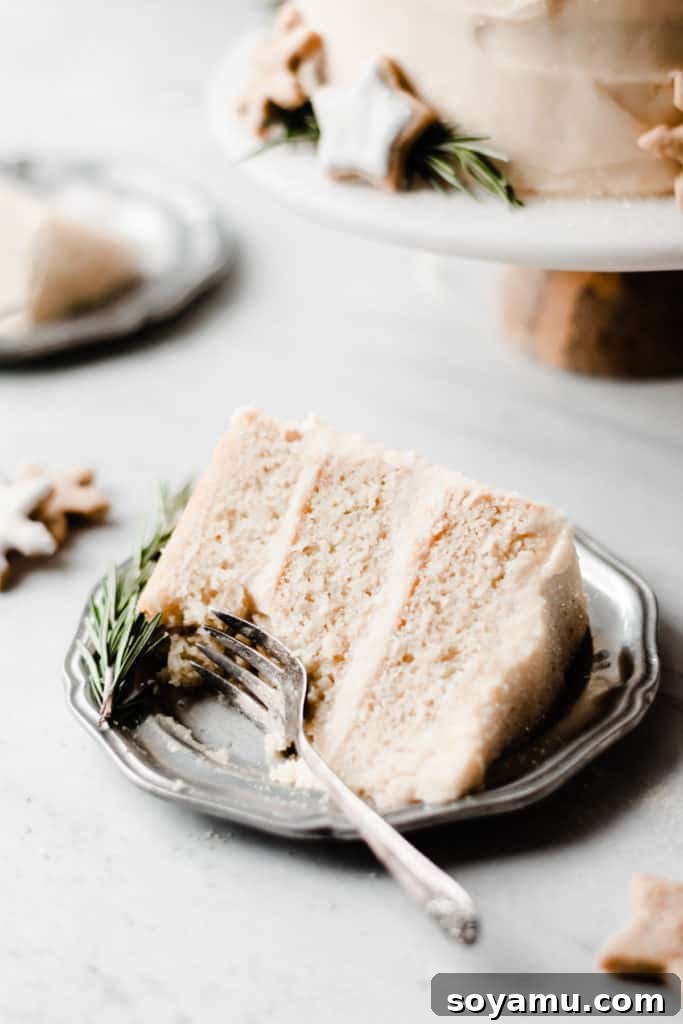 Moist cake layers with creamy white chocolate frosting A slice of Caramelized White Chocolate Winter Wonderland Cake on a plate