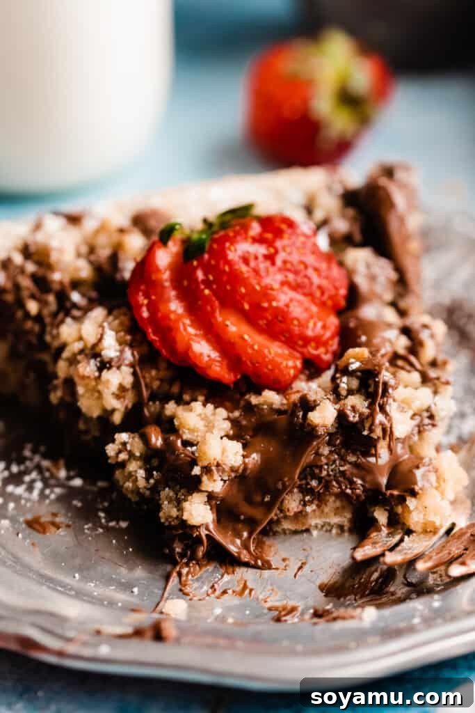 A very close-up on a slice of nutella pizza with a bite missing.